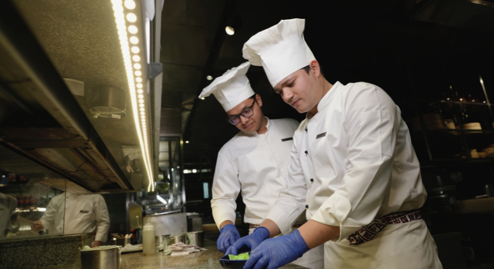 Professional chef in dark kitchen with dramatic backlighting